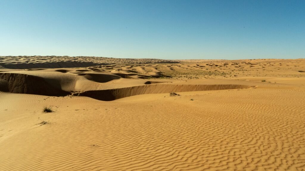 Expansive golden sand dunes under a clear blue sky
