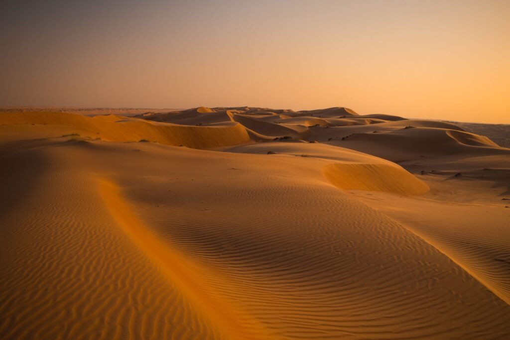 Golden sand dunes at sunset in the Omani desert