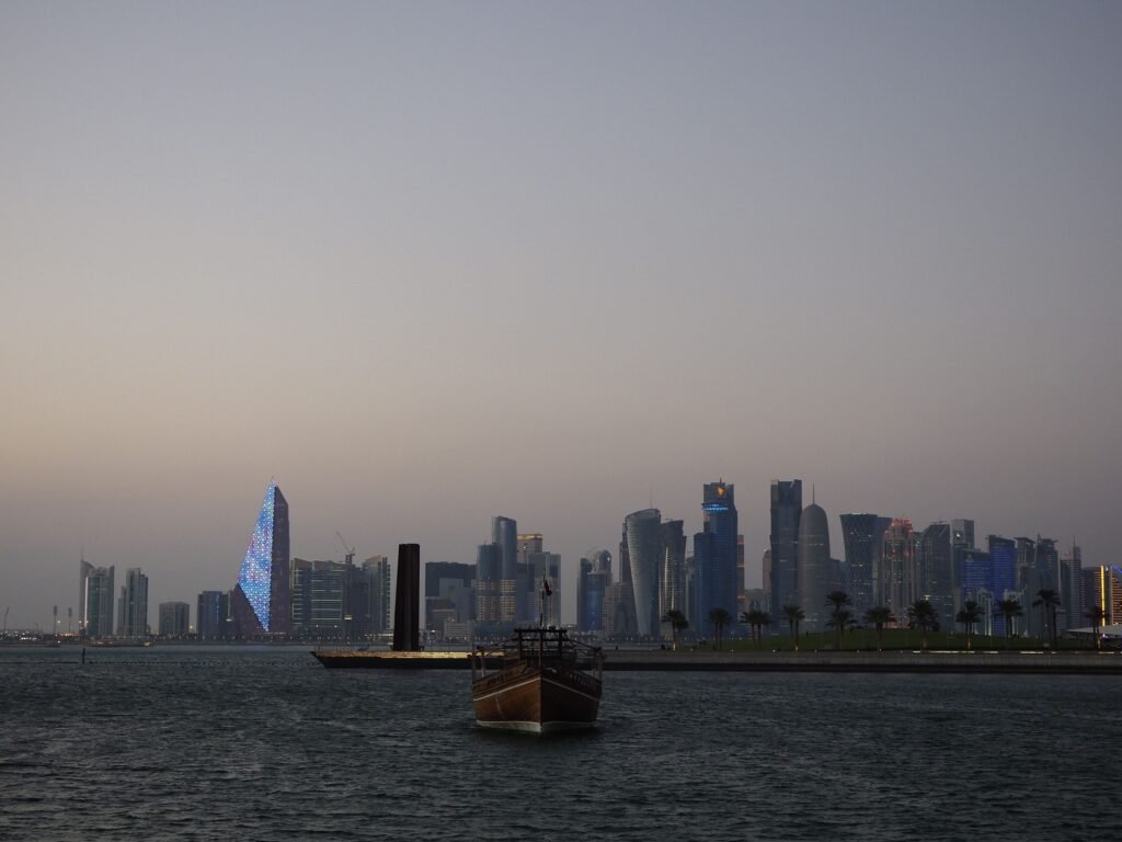 Doha skyline with a traditional dhow boat at dusk